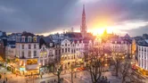 Brussels, Belgium plaza and skyline with the Town Hall tower at dusk.