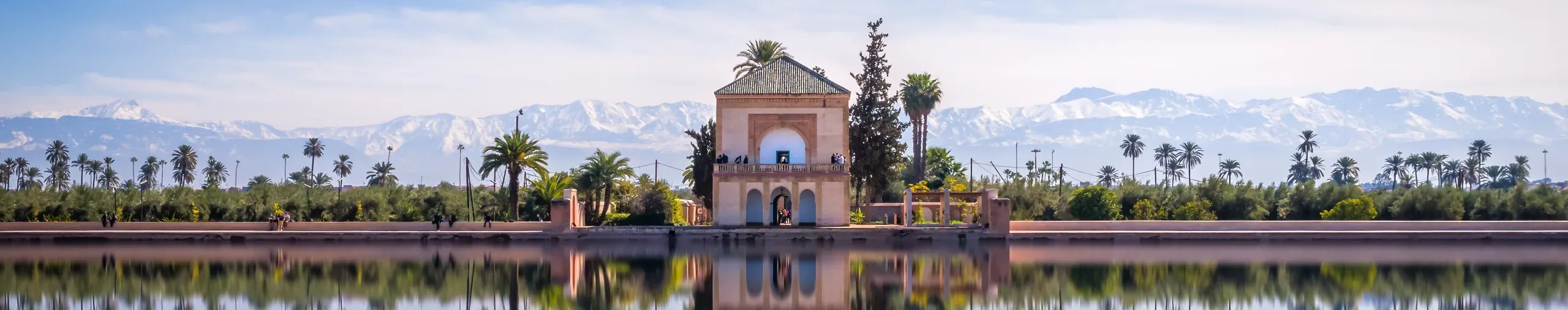 The Saadian Pavilion at the Menara Gardens, with water, palm trees and distant mountains, Marrakech, Morocco.