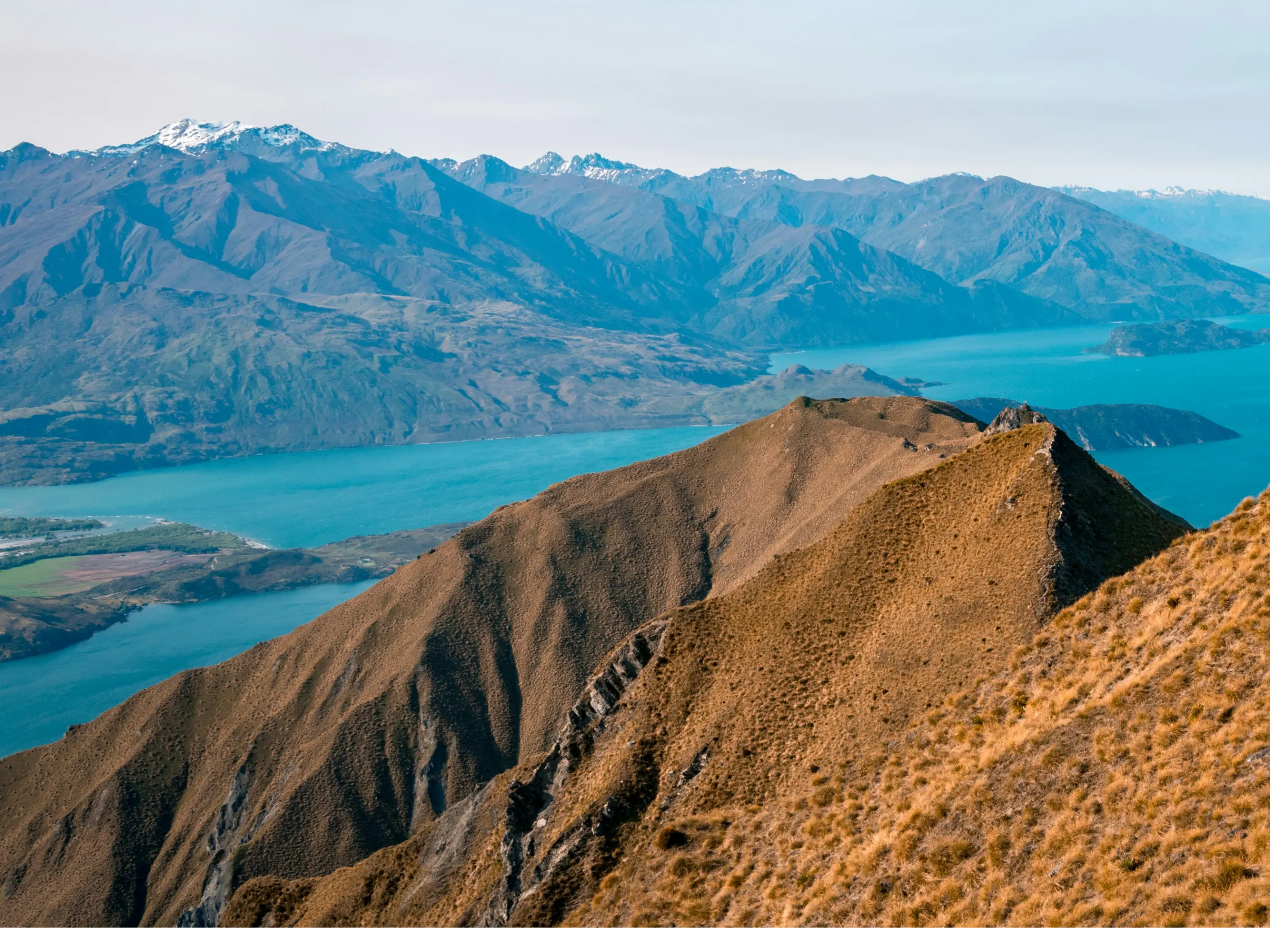 Dramatic scenery of lakes and mountains, surrounding the summit of Roys Peak in Wānaka, New Zealand