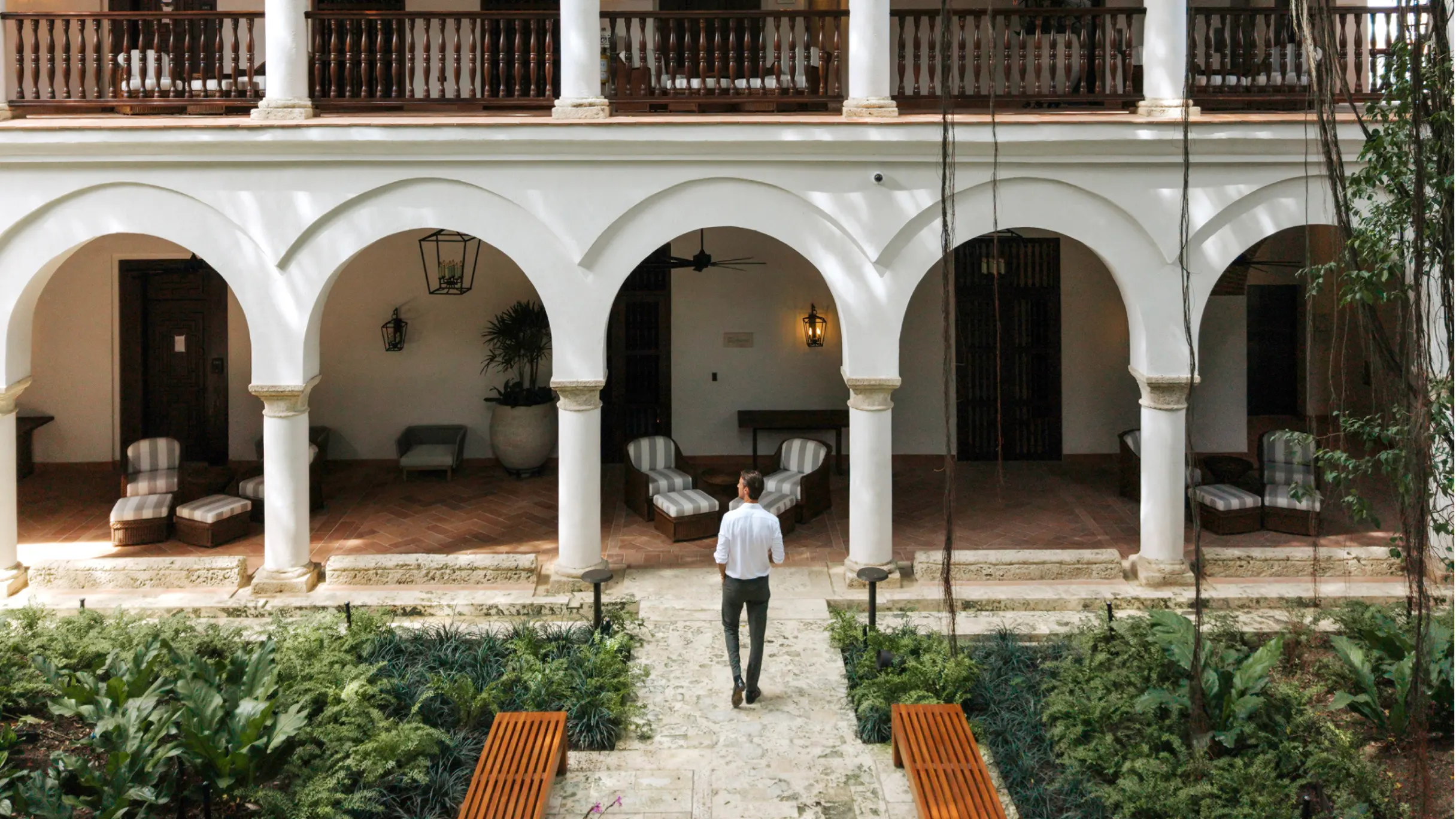 Man stands in garden of luxury hotel